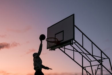 slam dunk basketball isolated sunset. scoring silhouette dunking man outdoors
