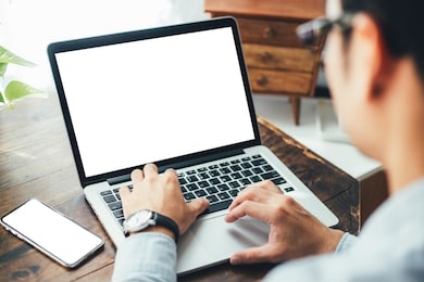 mockup image blank screen computer,cell phone with white background for advertising text,hand man using laptop texting mobile contact business search information on desk in office.marketing and design