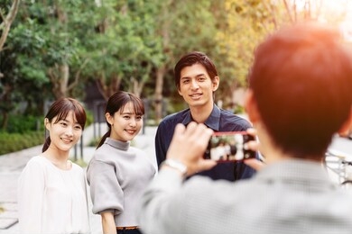 group of asian people taking a photo with a smart phone.