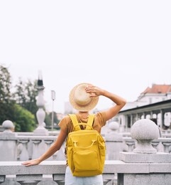 travel slovenia, europe. young girl with backpack on triple bridge in heart of ljubljana old town. back view of woman tourist on the background of city architecture. local living in ljubljana