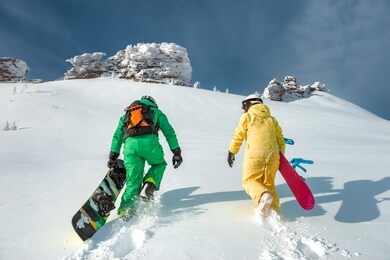 two snowboarders walking uphill. backcountry skiing and snowboarding concept at ski resort