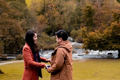 happy attractive asian couple fall in love make proposal to get married engagement with diamond ring, beautiful woman crying in tears, young newlywed have holiday honeymoon in beautiful autumn season
