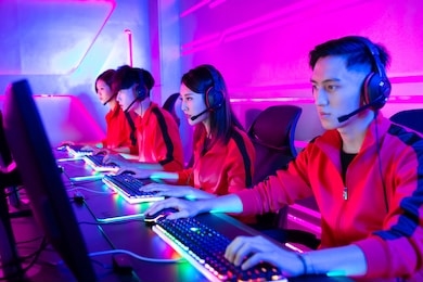 team of asian teenage cyber sport gamers play in multiplayer pc video game on esport tournament