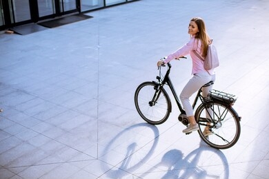 pretty young woman with modern city electric e-bike clean sustainable urban transportation