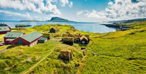 panoramic morning view of typical turf-top houses. picturesque summer scene of outskirts of torshavn city, capital of faroe islands, kingdom of denmark, europe. traveling concept background.