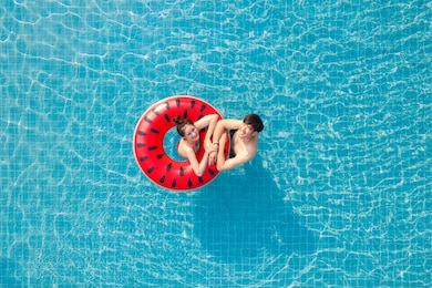 asian couple in love in swimming pool on summer time, this image can use for valentine day, resort, relax, hotel, water sport and spa concept