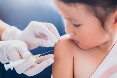 little child having injection,close-up doctor injecting vaccination to arm of asian little girl vaccine in hospital health and medical concept