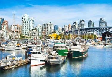 beautiful view of vancouver skyline with granville bridge and ships lying in harbor at false creek, british columbia, canada