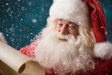 portrait of happy santa claus reading christmas letter outdoors at north pole at snowfall