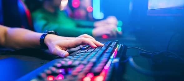 professional cyber video gamer studio room with personal computer armchair, keyboard for stream in neon color blur background. soft focus.