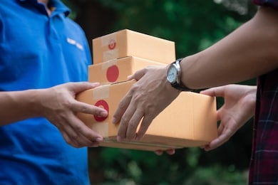 delivery man holding boxes person who sent the letter to the package box to the recipient to arrive at home

