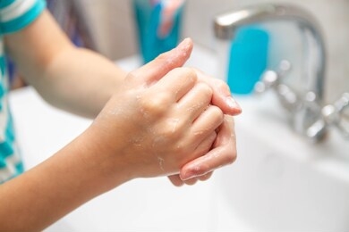 wash your hands with soap after a walk. the child washes his hands in the bathroom.