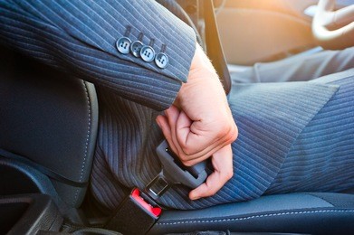 driver in business suit fastens his seat himself automobile seat belt