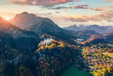 view from flying drone. incredible autumn sunrise on neuschwanstein castle, 19th-century hilltop fairytale castle. perfect morning scene of bavaria. colorful landscape of alps, germany, europe.