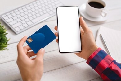 online payment. man holding smartphone with blank screen and credit card, making financial transaction