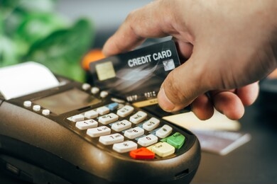 businessman hand pushing the button and swipe credit on terminal standing in shopping mall. shopping and retail concept