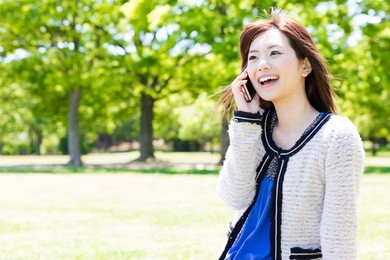 attractive asian woman talking in the park