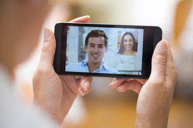closeup of a female hand holding a smart phone during a skype video call with her friend 