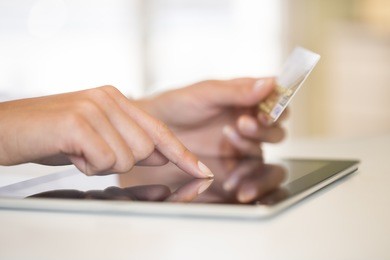 close-up woman's hands holding a credit card and using tablet pc for online shopping