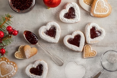 homemade heart shaped  cookies with raspberry jam on white wooden table  for christmas or  valentine's day. top view.