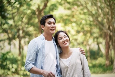 happy loving young asian couple relaxing in park