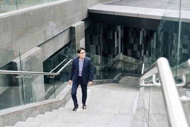 handsome young asian businessman walking up the metro station or underground crossing