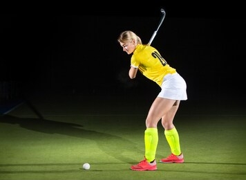 young girl field hockey player hit the ball in penalty stroke.