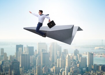 businessman flying on paper plane in business concept