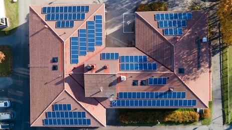 aerial top view of new modern residential house cottage with blue panels. renewable ecological green energy production concept.