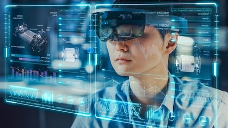 industrial factory chief engineer wearing ar headset designs a prototype of an electric car chassis on the holographic projection blueprint. futuristic virtual design of mixed technology application.