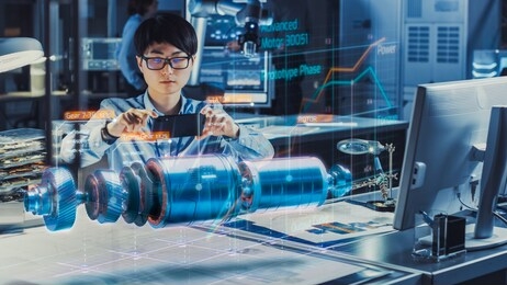 industrial engineer works with smartphone using augmented reality holographic projection 3d model of the electric motor prototype. development of virtual mixed reality application.