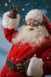 santa claus is listening to music in headphones outdoors at north pole, having fun while delivering gifts