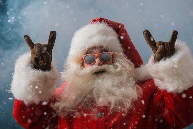 santa claus wearing sunglasses dancing outdoors at north pole in snowfall. he is celebrating christmas after hard work