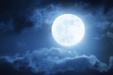 dramatic photo illustration of a nighttime sky with brightly lit clouds and large, bright full moon would make a great background.