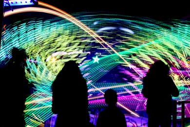 funfair attraction spinning around at a fast pace, creating light streaks