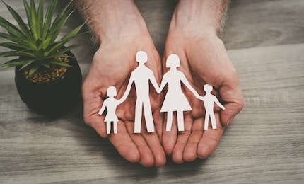 hands protecting a family; symbol of life insurance