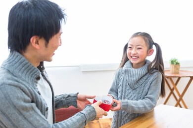 daughter giving chocolate to father