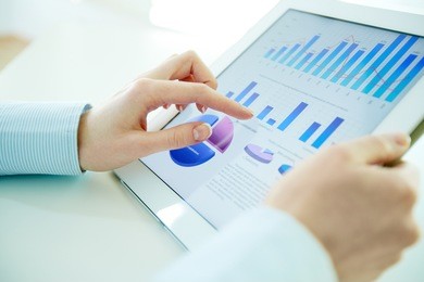 close-up image of an office worker using a touchpad to analyze statistical data