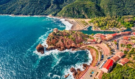 view from flying drone. incredible summer cityscape of porto town with genoise de porto ota tower. aerial morning view of corsica island, france, europe. traveling concept background.