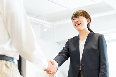 women in suits shaking hands with men