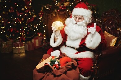santa claus brought gifts for christmas. he sits in an armchair in a beautiful christmas interior. christmas and new year concept. 