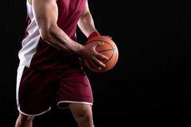 side view mid section of a muscular caucasian male basketball player wearing team colours holding a basketball in two hands during a game