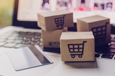 online shopping - paper cartons or parcel with a shopping cart logo and credit card on a laptop keyboard. shopping service on the online web and offers home delivery.