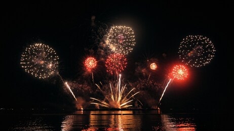 golden big shiny fireworks with bokeh lights in the night sky. glowing firework show. new year's eve fireworks celebration. fireworks festival.