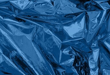 abstract trendy dark blue colored crumpled foil texture background. color trend concept.