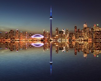 toronto skyline at night with a reflection in lake ontario. 