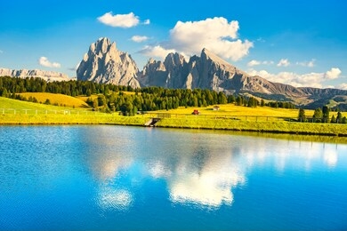 lake and mountains at sunset, alpe di siusi or seiser alm, dolomites alps sassolungo and sassopiato, trentino alto adige sud tyrol, italy, europe