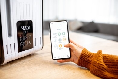 close-up on a smart phone with launched home assistant application, controlling air humidifier at home