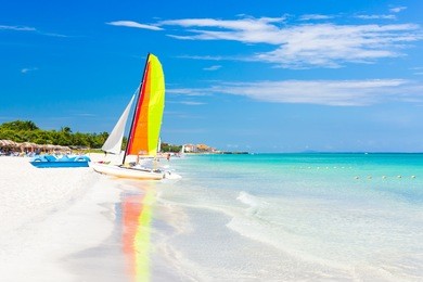 scene with sailing boat at the famous varadero beach , caribbean sea in cuba