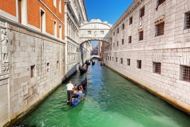 venice, italy. the bridge of sighs, gondola floats on a canal among old venetian architecture
